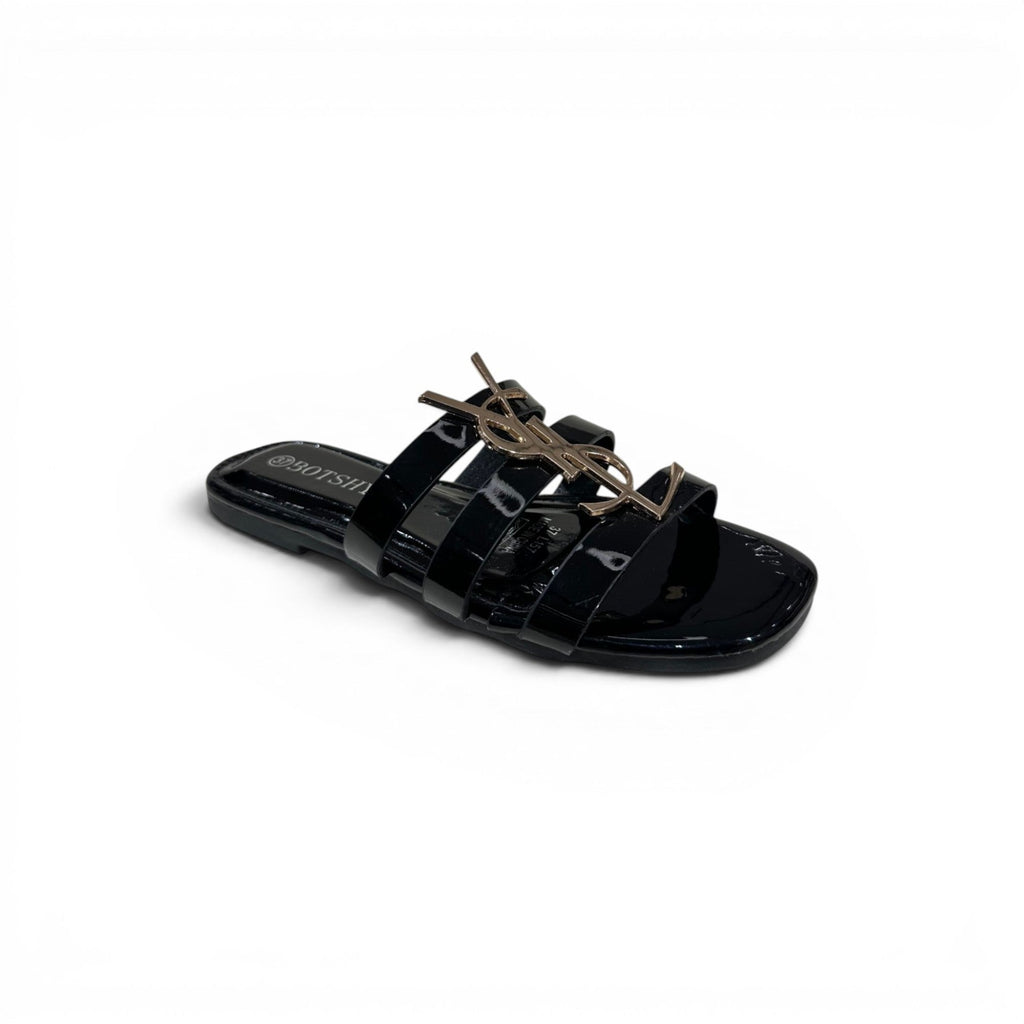 COC Store black patent leather slide sandals with gold interlocking buckle accent and multiple straps.