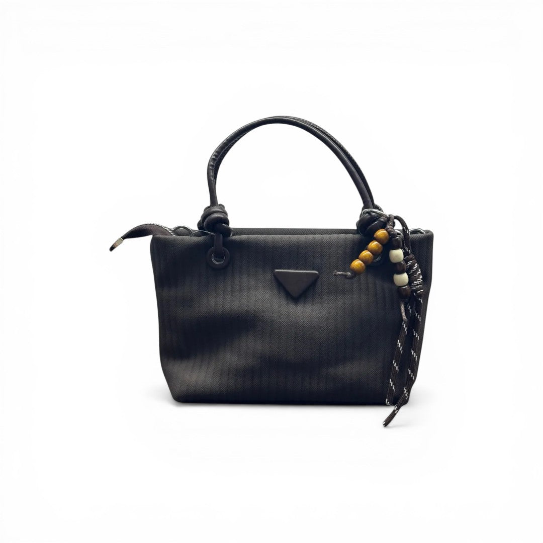COC Store black textured tote bag with faux leather handles and beaded charm.