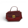 COC Store burgundy faux leather and suede satchel bag with gold clasp and top handle.