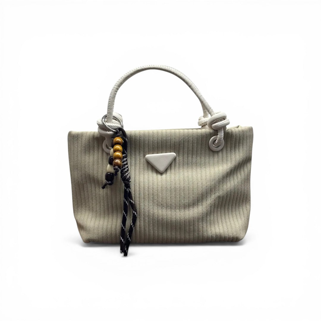COC Store cream textured tote bag with faux leather handles and beaded charm.