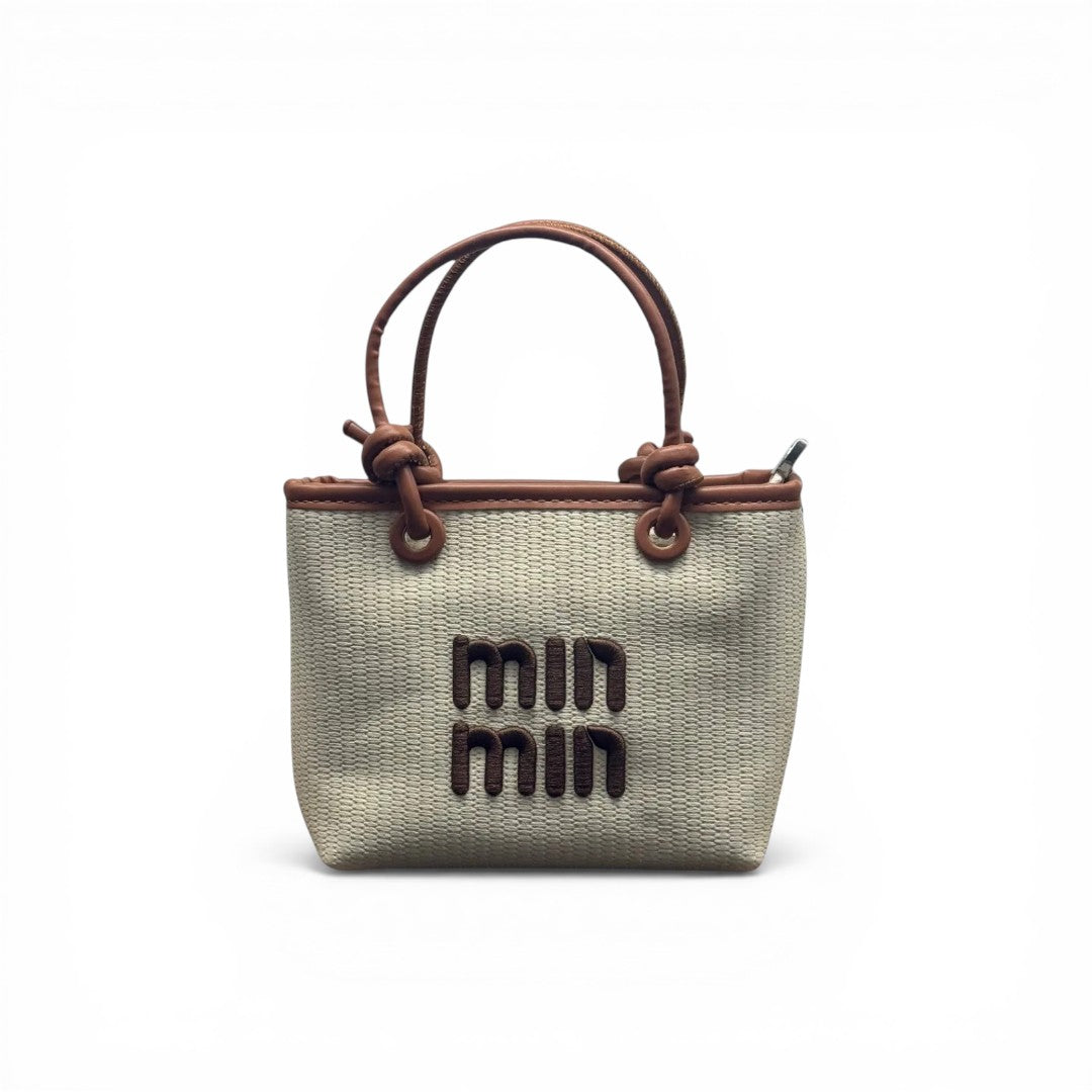 COC Store woven tote bag with faux leather trim and knot details on handles. Beige with brown logo.